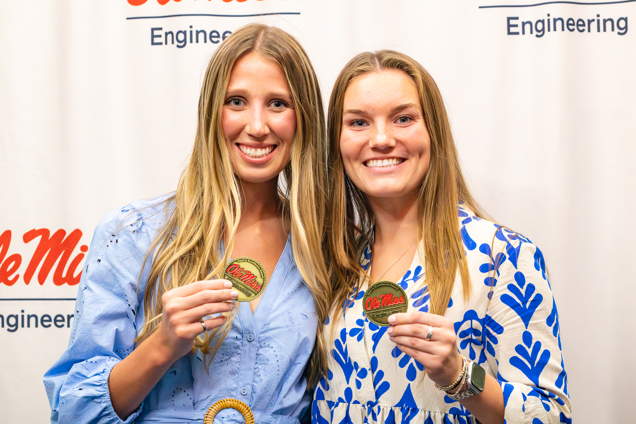 Two students smiling and holding awards