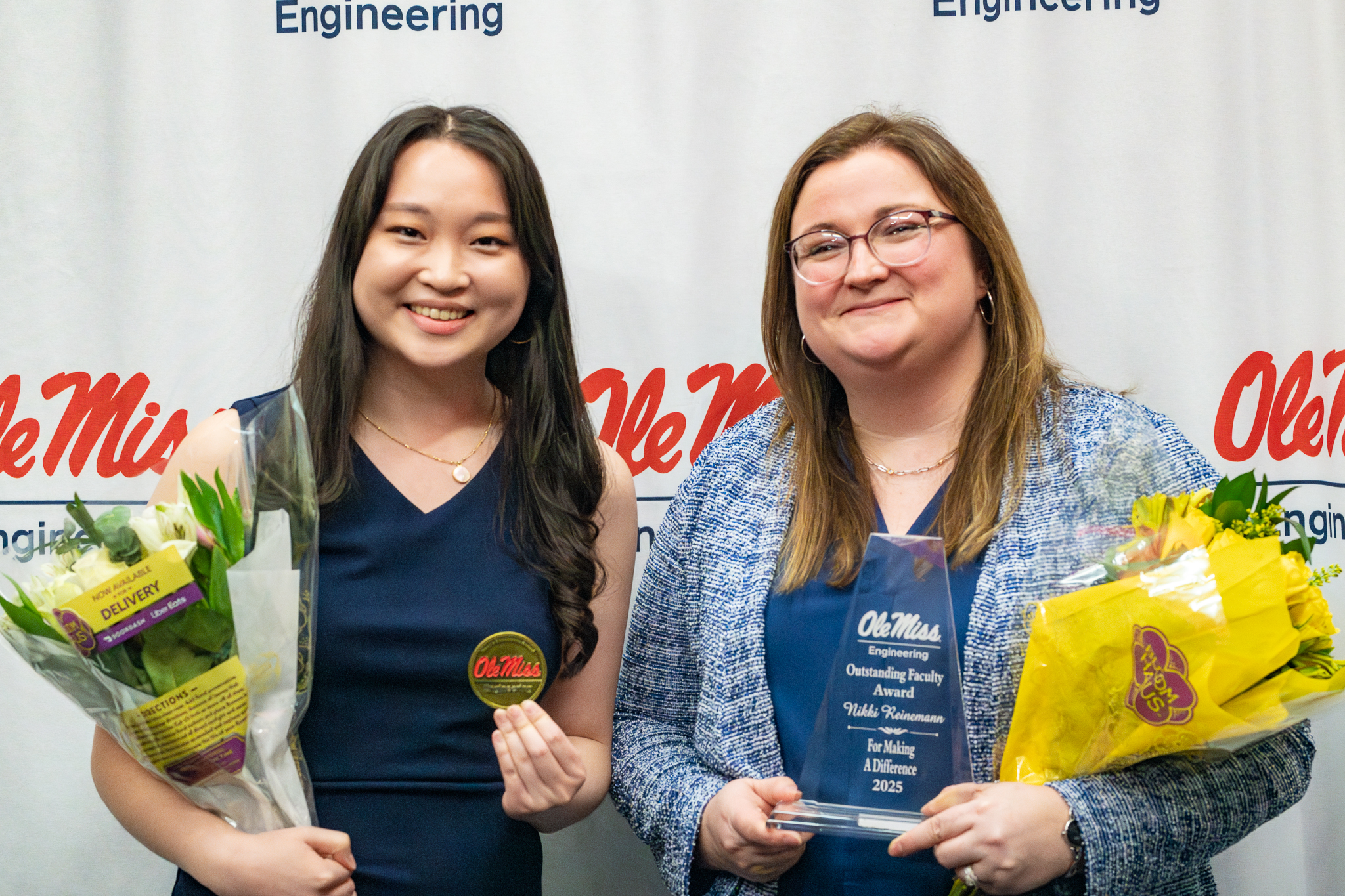 Student and professor holding award and flowers