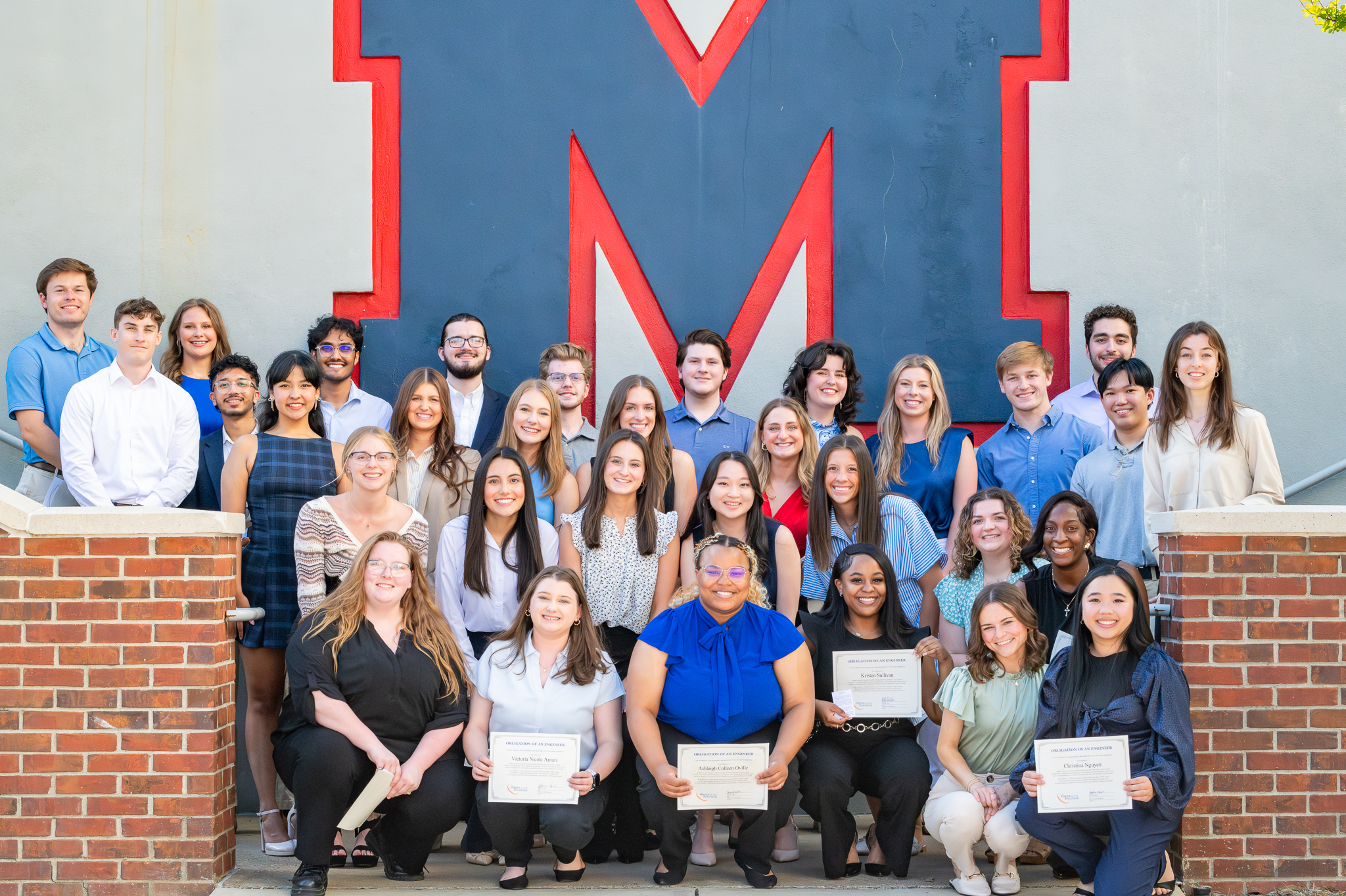Students from biomedical engineering pose for a photo with their order of the engineer certificates.