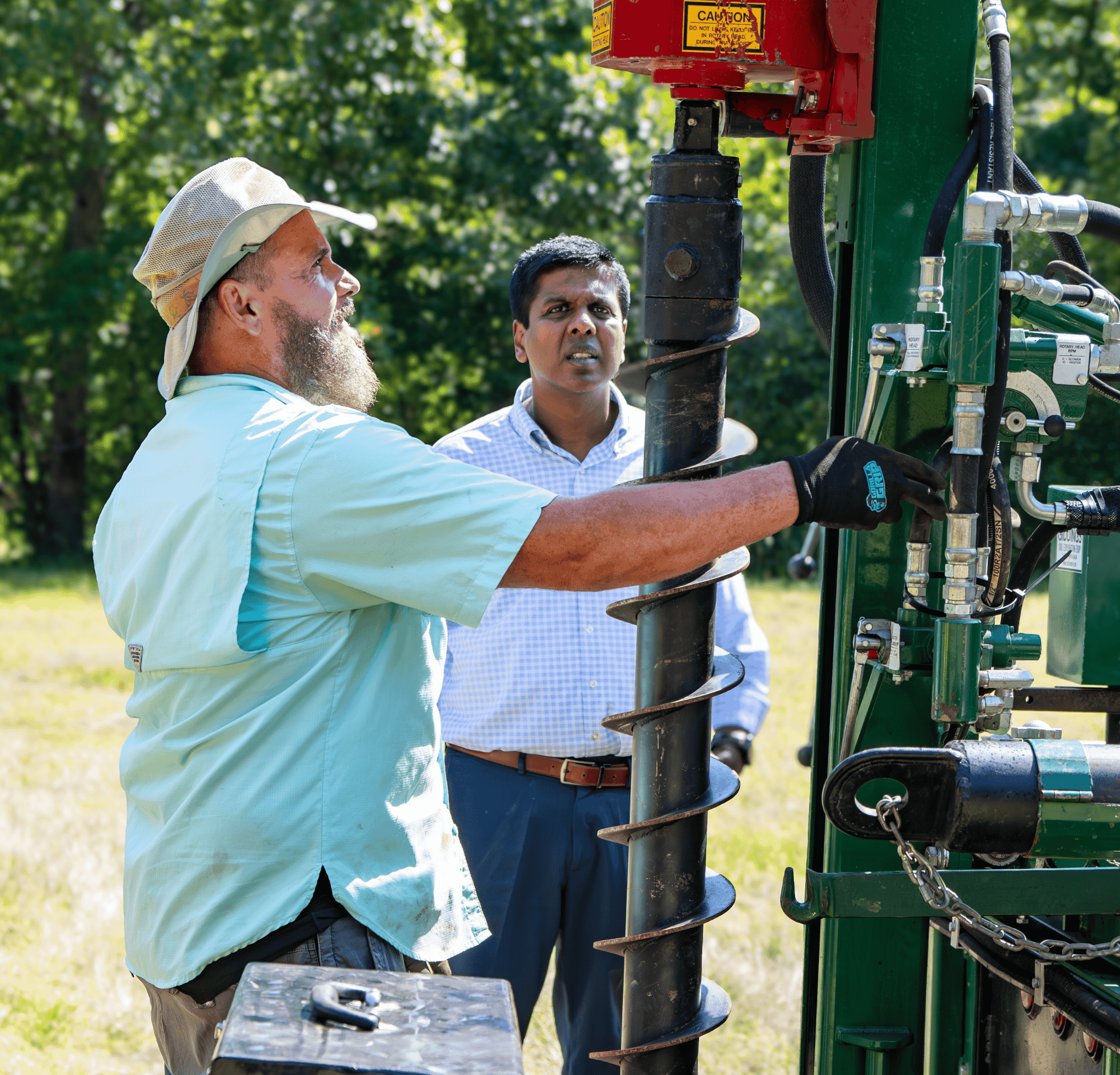 Two men working on equipment outside