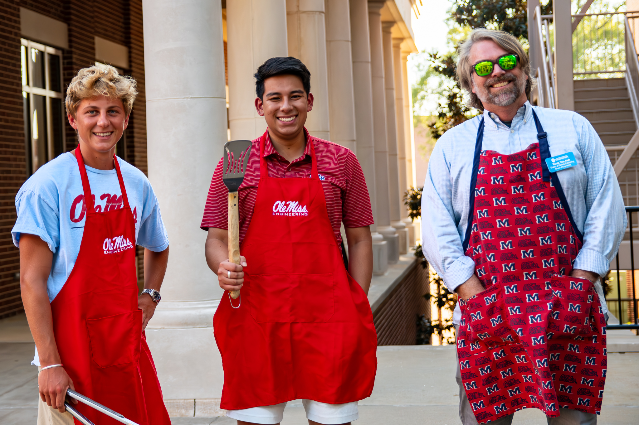 Two students and one faculty member smiling