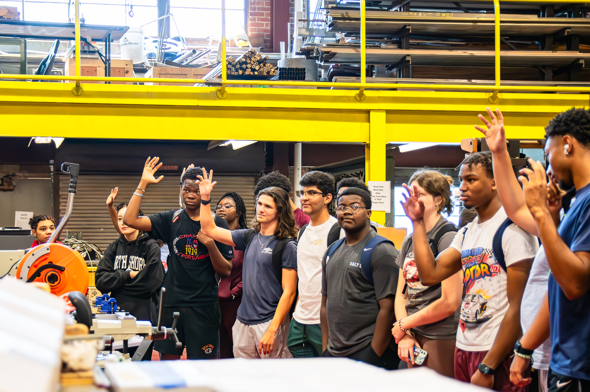 Students in machine shop; some raising hands
