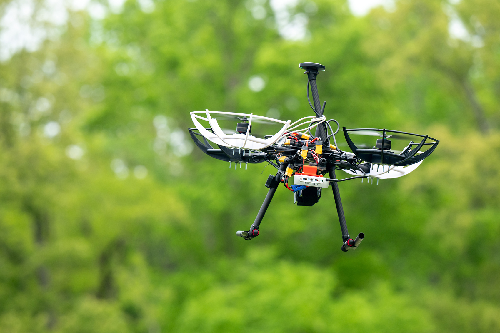 The Ole Miss design team's UAV—featuring a Pixhawk 6C flight  controller running Ardupilot, a Raspberry Pi 5 computer, an Intel depthsense 435i and more—in flight during pre-competition testing.
