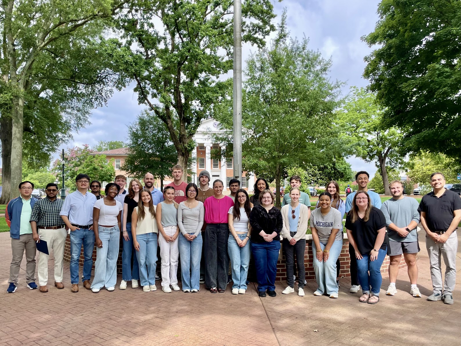 A group photo showing a group of students and faculty outdoors in front of the Lyceum building on the Ole Miss campus.