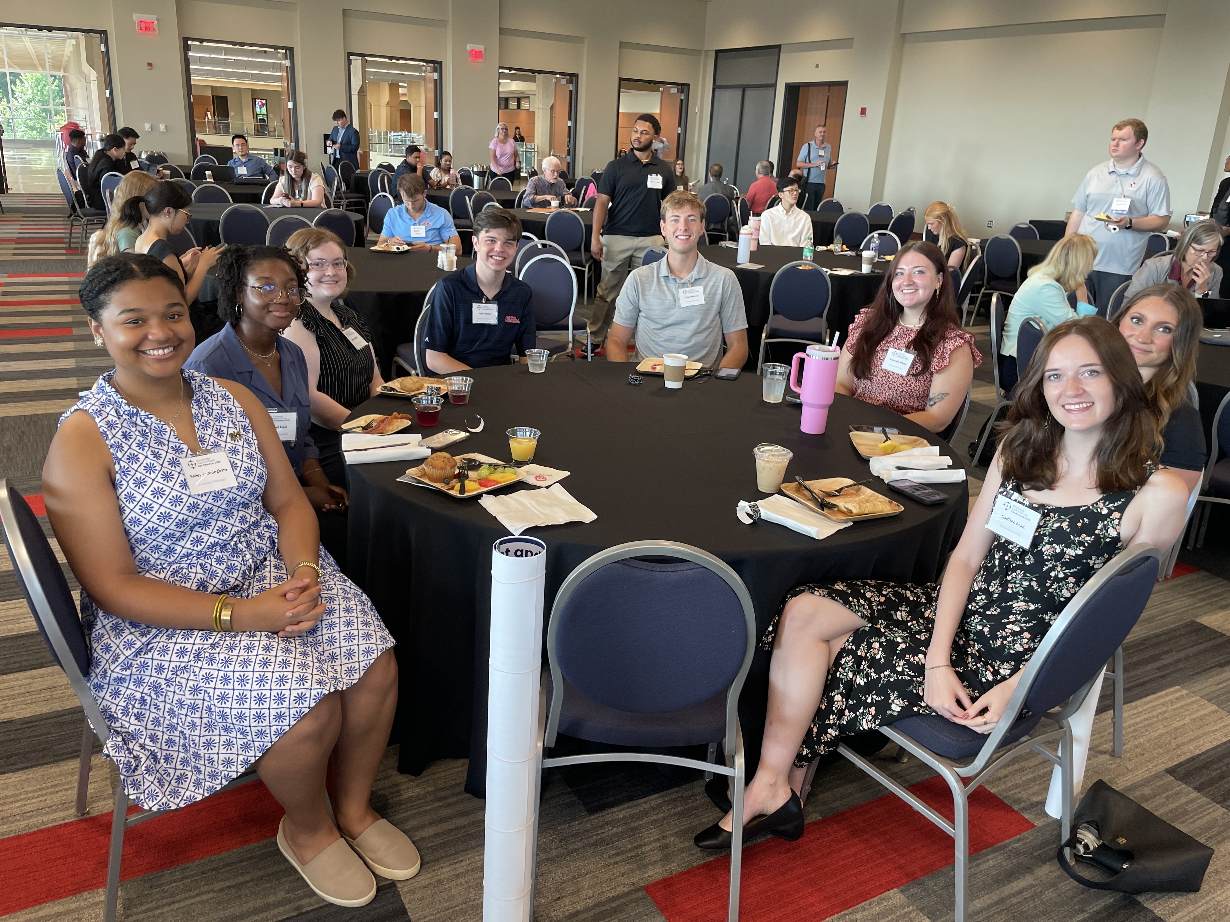 A group photo of 2025's REU students seated in the student union enjoying a brunch.
